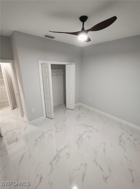 unfurnished bedroom featuring a ceiling fan, a closet, visible vents, and marble finish floor