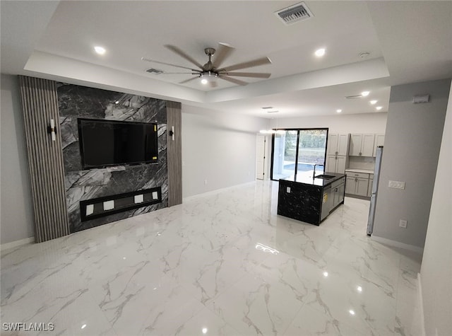 living area featuring marble finish floor, visible vents, a raised ceiling, and recessed lighting