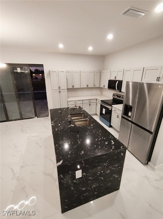 kitchen featuring visible vents, appliances with stainless steel finishes, light stone counters, marble finish floor, and a sink