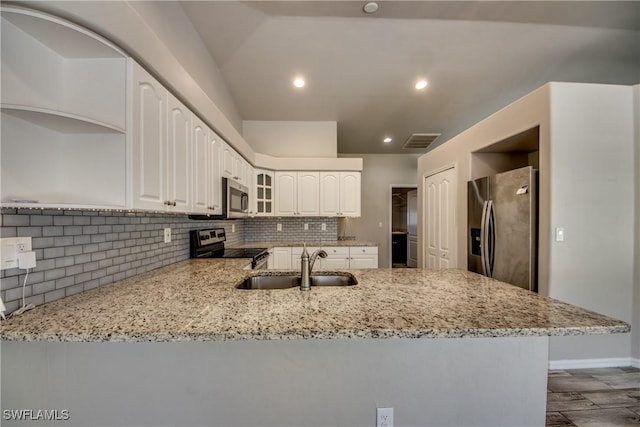 kitchen with appliances with stainless steel finishes, light stone countertops, a sink, and open shelves