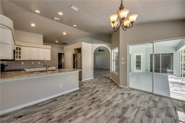 kitchen featuring range with electric stovetop, visible vents, vaulted ceiling, a sink, and stainless steel fridge