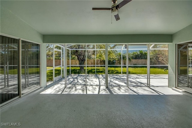 unfurnished sunroom with ceiling fan