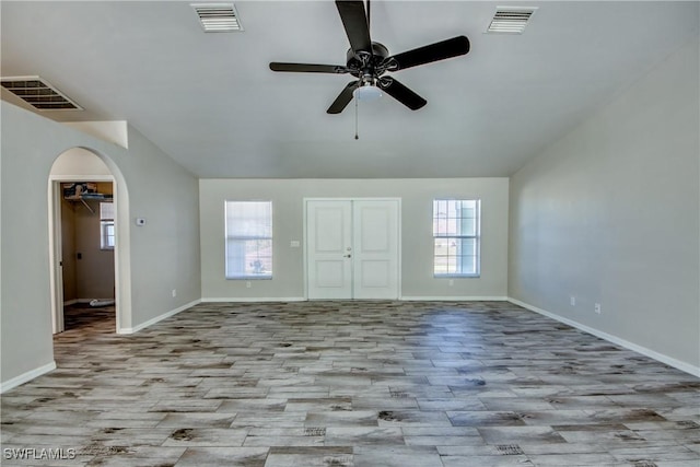 interior space with arched walkways, lofted ceiling, and visible vents