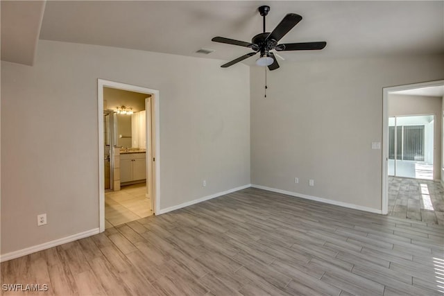 unfurnished bedroom featuring light wood finished floors, connected bathroom, visible vents, and baseboards