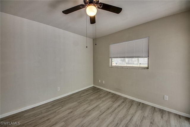 spare room featuring a ceiling fan, baseboards, and wood finished floors