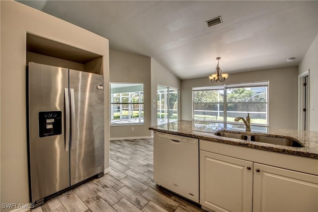 kitchen with white dishwasher, a sink, visible vents, white cabinets, and stainless steel refrigerator with ice dispenser