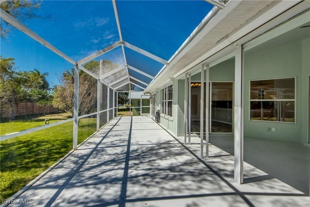 view of patio with a lanai and fence