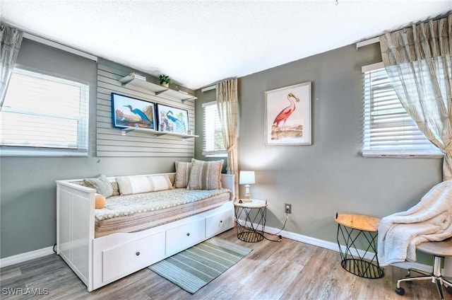 bedroom with baseboards and wood finished floors