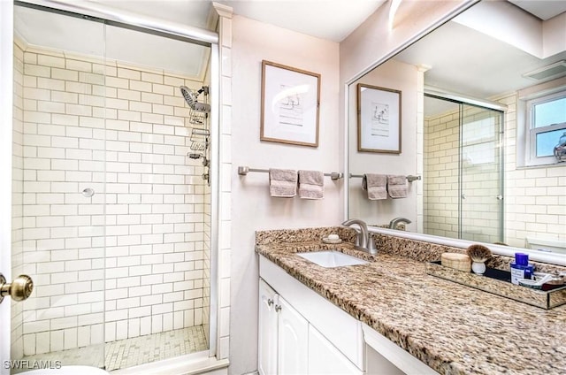 bathroom with a stall shower, visible vents, and vanity