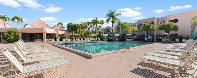 community pool with a patio and fence