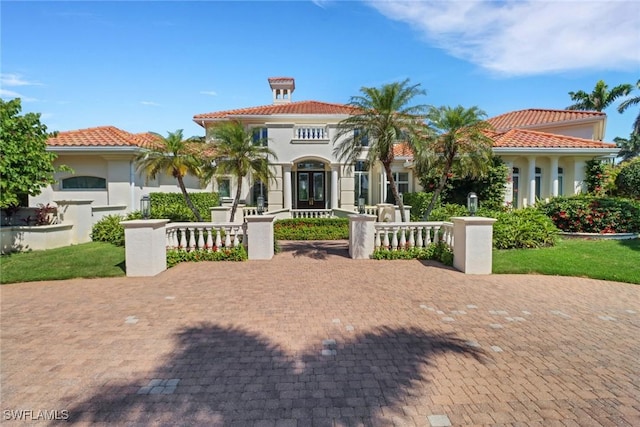 mediterranean / spanish-style home featuring french doors, a tile roof, and stucco siding