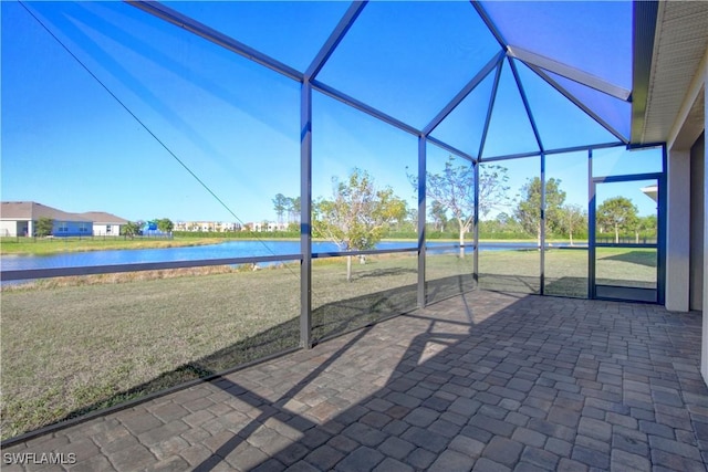 view of patio / terrace featuring a water view and glass enclosure