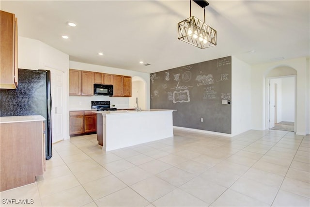 kitchen featuring arched walkways, brown cabinets, light countertops, black appliances, and recessed lighting