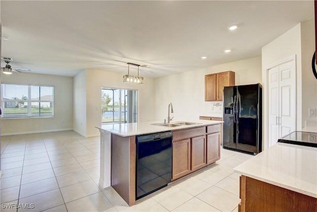 kitchen featuring black appliances, brown cabinetry, a sink, and light countertops