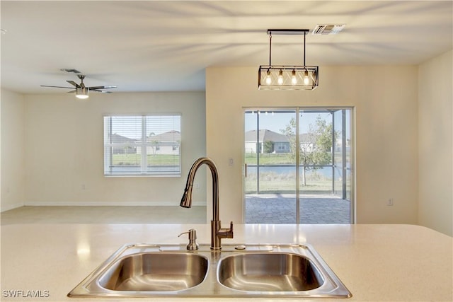 room details with a sink, a ceiling fan, visible vents, light countertops, and decorative light fixtures