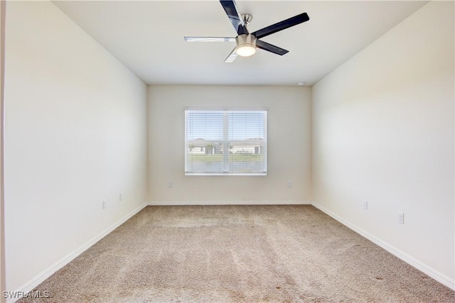 carpeted spare room with baseboards and a ceiling fan