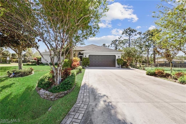 single story home with concrete driveway, an attached garage, fence, a front yard, and stucco siding