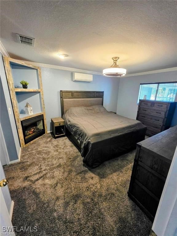 bedroom with visible vents, crown molding, carpet flooring, a textured ceiling, and a wall mounted AC