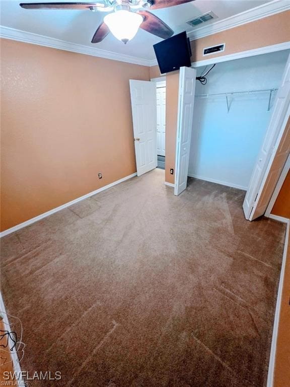 unfurnished bedroom with baseboards, visible vents, crown molding, carpet flooring, and a closet