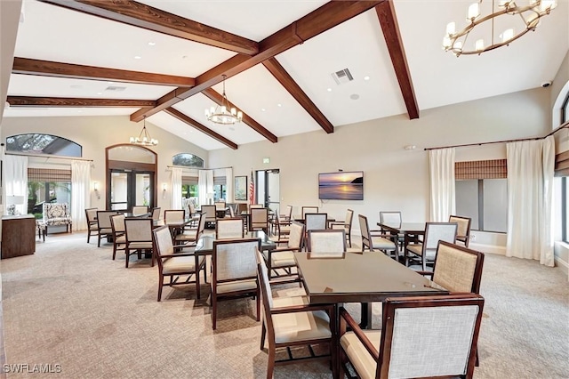 dining area with high vaulted ceiling, light carpet, visible vents, french doors, and an inviting chandelier