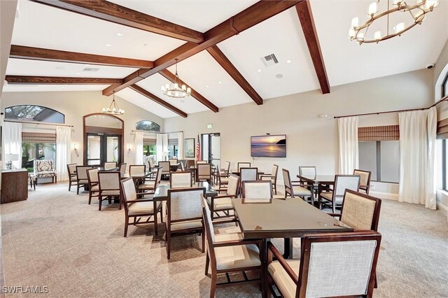 dining area featuring a chandelier, light colored carpet, plenty of natural light, beam ceiling, and high vaulted ceiling