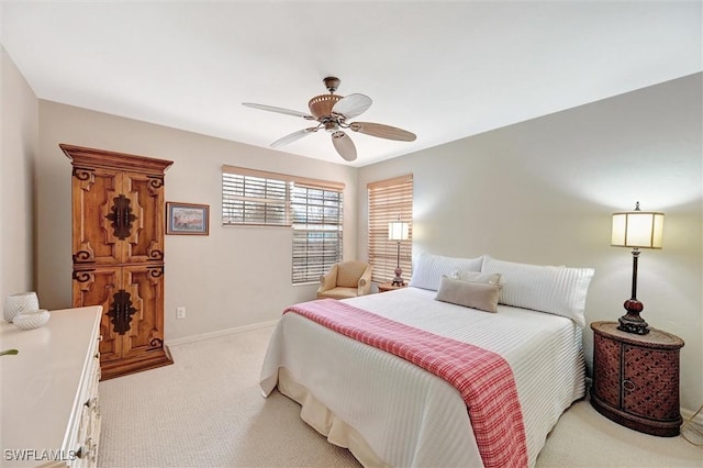 bedroom with a ceiling fan, light colored carpet, and baseboards