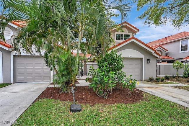 view of front of house with an attached garage, a tile roof, concrete driveway, and stucco siding