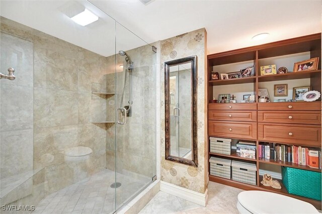 full bathroom with toilet, a shower stall, tile patterned floors, and baseboards
