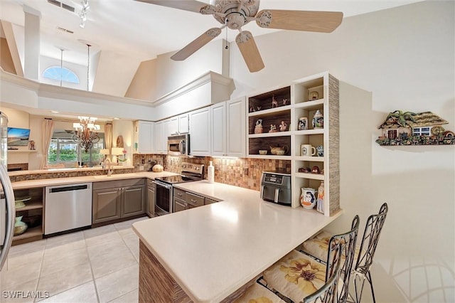 kitchen featuring light tile patterned floors, stainless steel appliances, a peninsula, backsplash, and open shelves