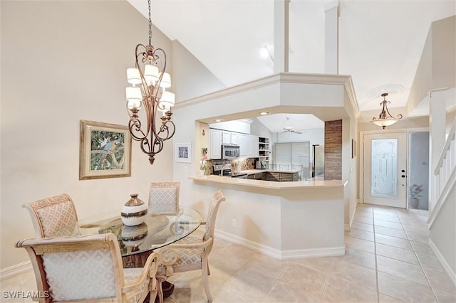 dining area with arched walkways, high vaulted ceiling, light tile patterned floors, baseboards, and stairway