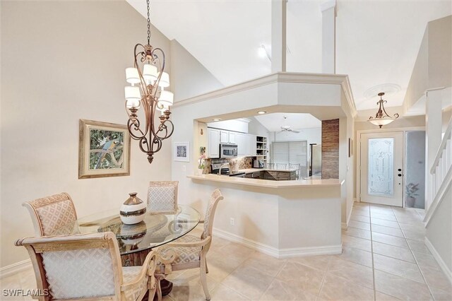 dining room with light tile patterned flooring, a chandelier, baseboards, and high vaulted ceiling