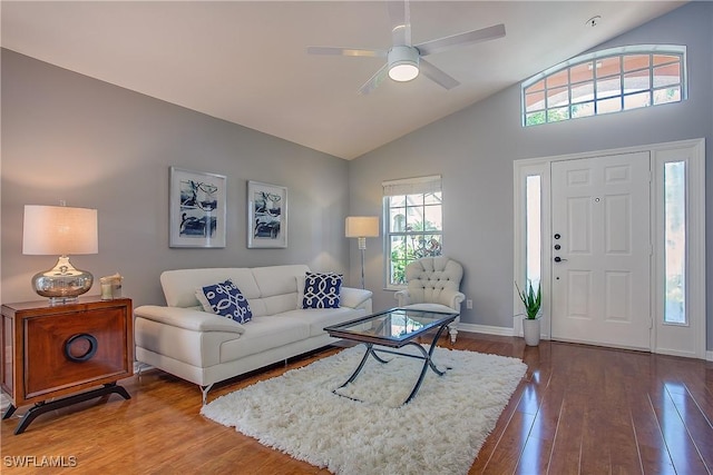 living area with ceiling fan, high vaulted ceiling, baseboards, and hardwood / wood-style floors