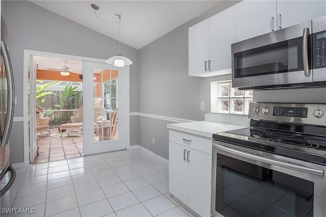 kitchen featuring vaulted ceiling, white cabinets, light countertops, appliances with stainless steel finishes, and pendant lighting