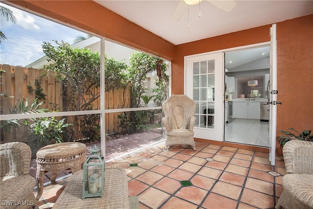 sunroom featuring lofted ceiling and ceiling fan