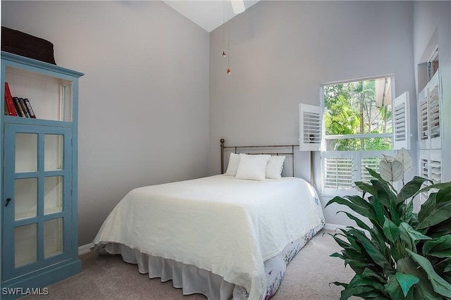 carpeted bedroom featuring high vaulted ceiling