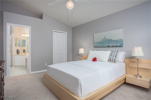 bedroom featuring a ceiling fan, ensuite bath, a closet, carpet, and vaulted ceiling