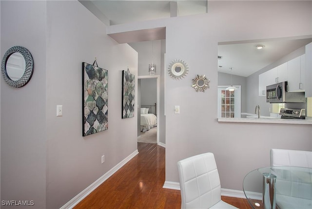 dining space featuring baseboards, lofted ceiling, and dark wood-style floors