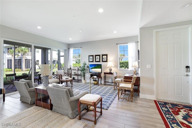 living room with recessed lighting, baseboards, a healthy amount of sunlight, and light wood finished floors