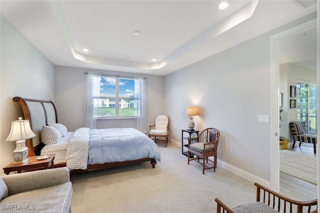 bedroom with a tray ceiling, multiple windows, recessed lighting, and baseboards