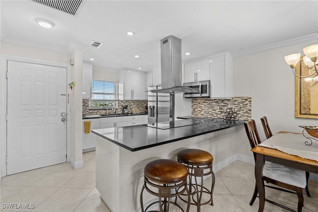 kitchen with visible vents, appliances with stainless steel finishes, island range hood, light tile patterned flooring, and a sink