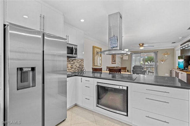 kitchen featuring dark countertops, appliances with stainless steel finishes, a peninsula, and crown molding