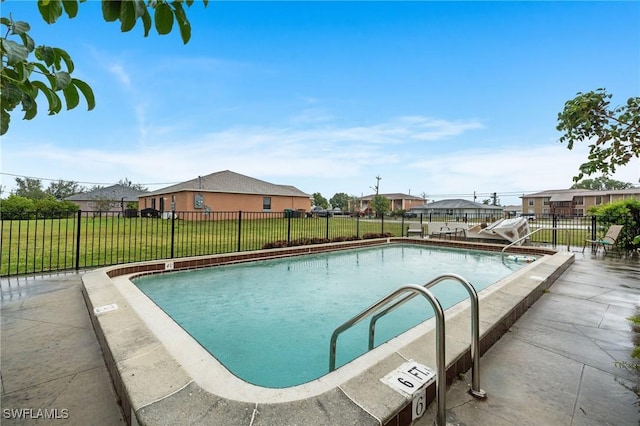 community pool with a yard, a residential view, and fence