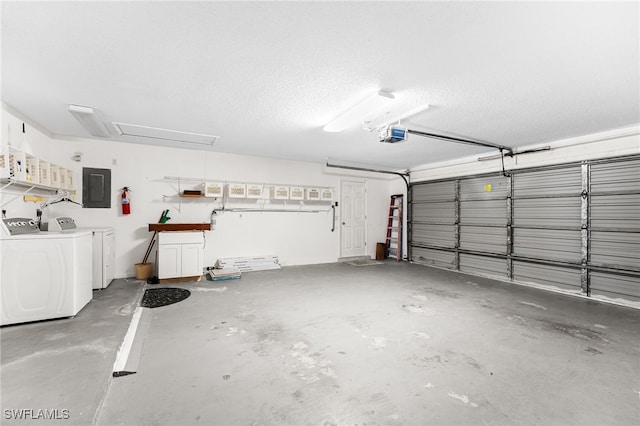 garage featuring a garage door opener, electric panel, and independent washer and dryer