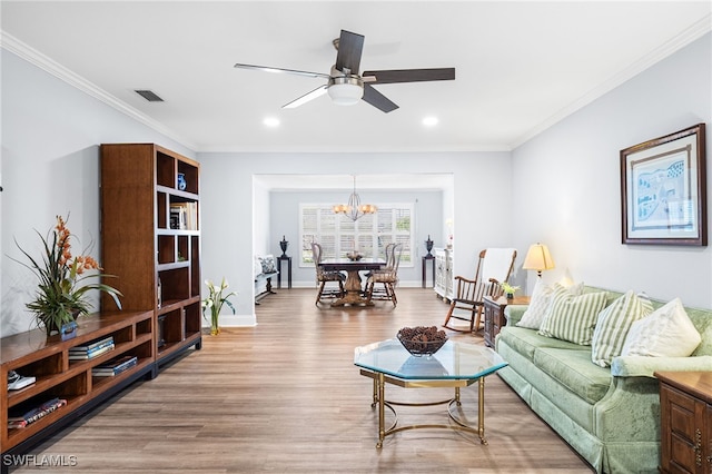 living room featuring baseboards, visible vents, wood finished floors, and ornamental molding