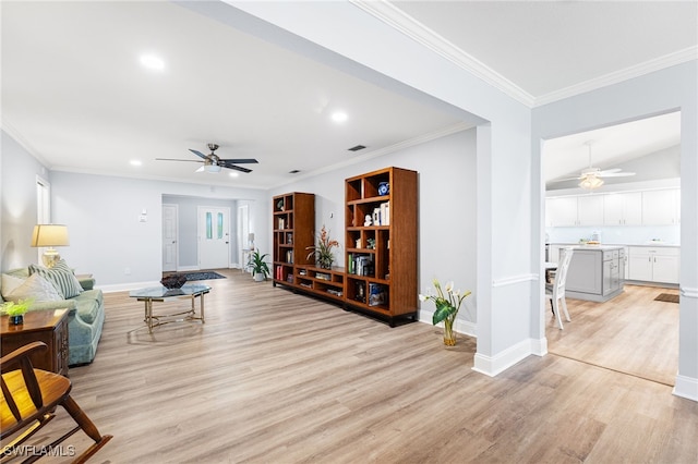 living room featuring ornamental molding, baseboards, light wood finished floors, and a ceiling fan