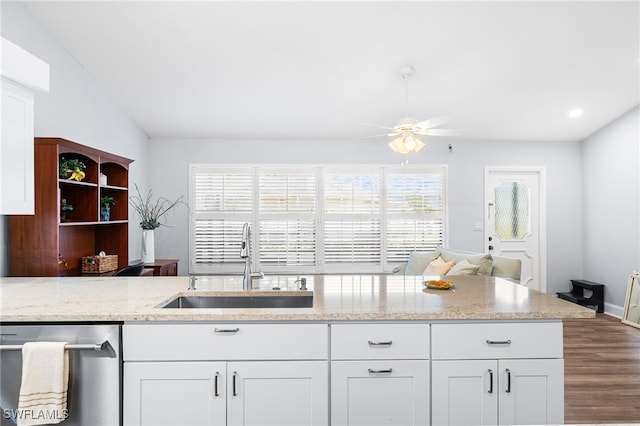 kitchen with a wealth of natural light, dishwasher, a sink, and light stone countertops