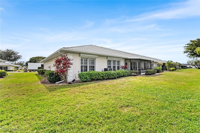 back of property featuring stucco siding and a yard