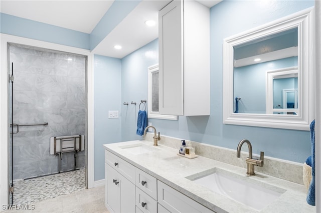 full bath featuring double vanity, a stall shower, a sink, and recessed lighting