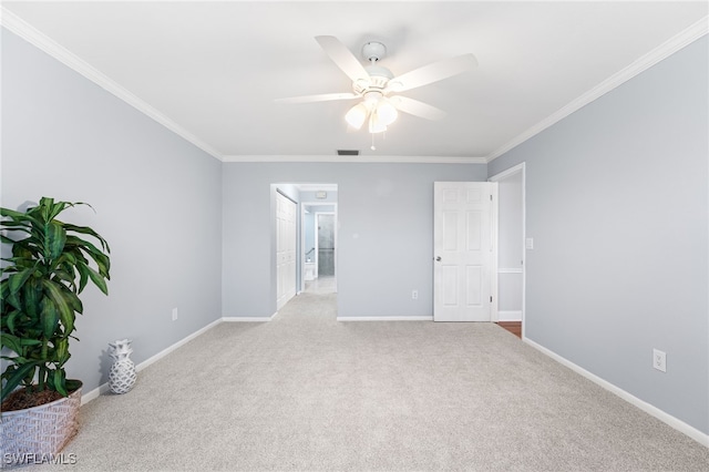 empty room with light carpet, visible vents, baseboards, and crown molding