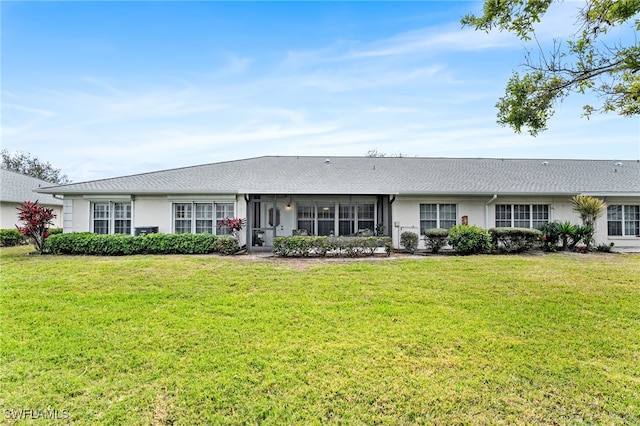 ranch-style home with a sunroom, a front lawn, and stucco siding